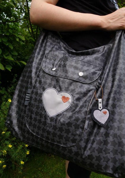 Große Umhängetasche mit aufgesetzter Vordertasche, genäht aus beschichteter Baumwolle.