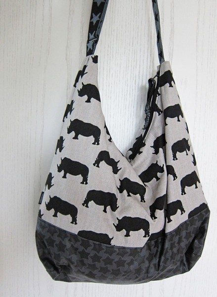 Lässige Umhängetasche aus Leinenstoff mit aufgedruckten Nashörnern.